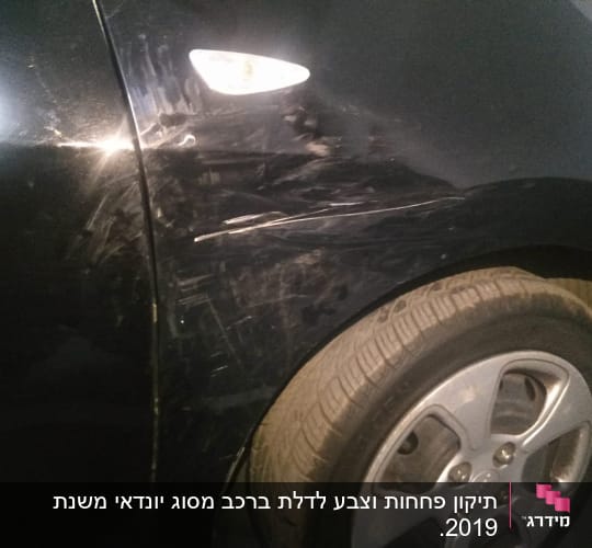 שריטות על דופן רכב שחור ליד גלגל